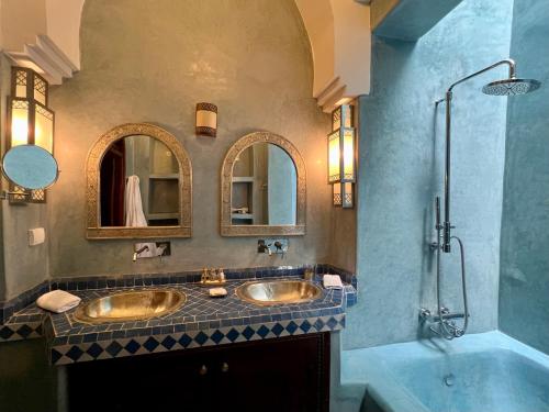 a bathroom with two sinks and a shower at Riad Sassa Finda in Marrakesh