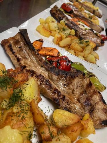 a plate of food with meat potatoes and vegetables at Nicole Hotel & Restaurant in Samokov
