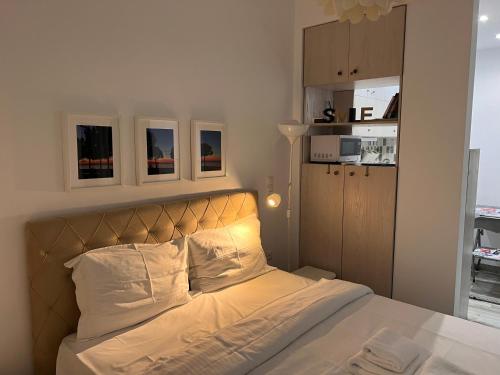um quarto com uma cama com lençóis brancos e almofadas brancas em Small budget diamond apartment in Agias Sofias. em Tessalônica