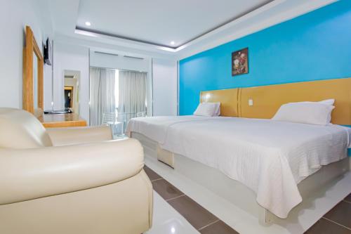 Habitación de hotel con 2 camas y sofá en Hotel La Casona Dorada, en Santo Domingo