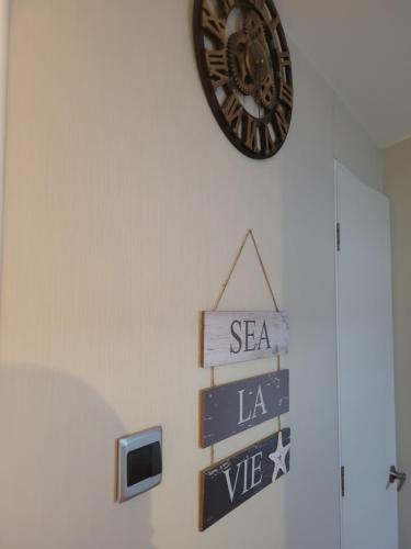 a clock hanging on a wall with street signs at Seawick Holiday Park in Saint Osyth