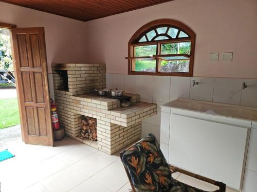 uma cozinha com um forno de tijolos e uma janela em LarDoceFesta Home em Pedra Azul