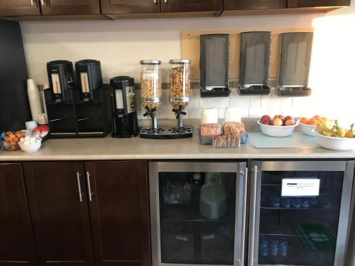 een toonbank met een koffiezetapparaat en een paar fruitschalen bij Super 8 by Wyndham Vermilion AB in Vermilion