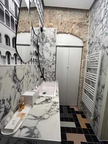 a bathroom with marble walls and a sink and a mirror at Apartment Luxury Palace No1 in Split