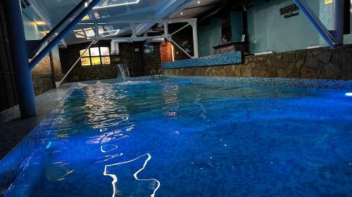een zwembad met blauw water in een gebouw bij Club Satelit Zlatibor in Zlatibor