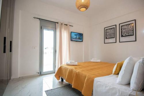 Μοντέρνο διαμέρισμα ALMYRA في آغيوس نيكولاوس: غرفة نوم بسرير واريكة ونافذة