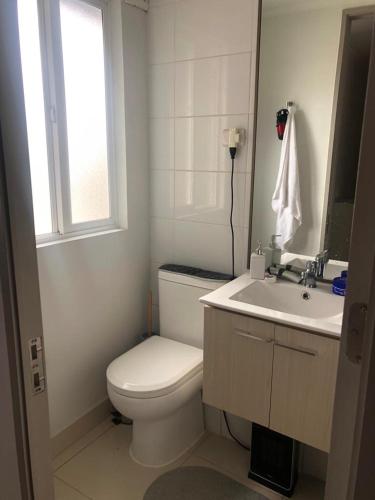 uma casa de banho branca com um WC e um lavatório em Habitación Bosquemar em Puerto Montt