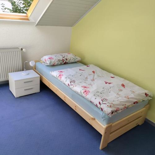 a bedroom with a bed and a night stand at Wohnung mit Weitblick in Neustadt an der Weinstraße