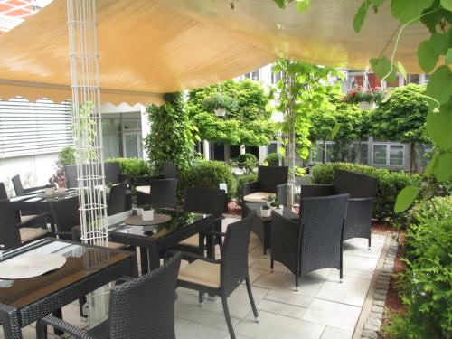 an outdoor restaurant with tables and chairs and plants at Best Western Hotel Am Straßberger Tor in Plauen