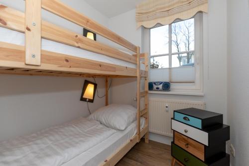 a bedroom with a bunk bed and a window at Strandjuwel 232 in Kühlungsborn