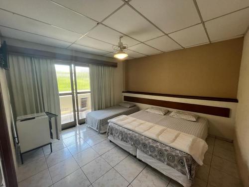 塞拉內格拉的住宿－Travessa 12 - Suítes centro de Serra Negra - SP，一间卧室设有两张床和窗户。