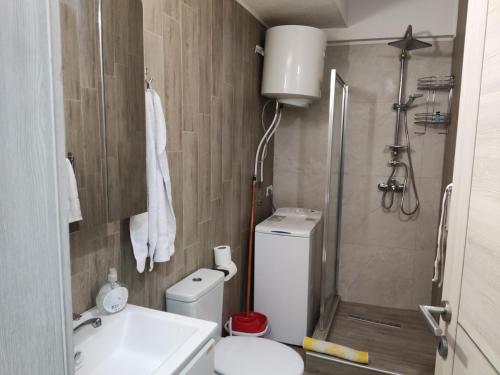 ein Bad mit einem WC, einem Waschbecken und einer Dusche in der Unterkunft Sarah's Apartments in Skopje