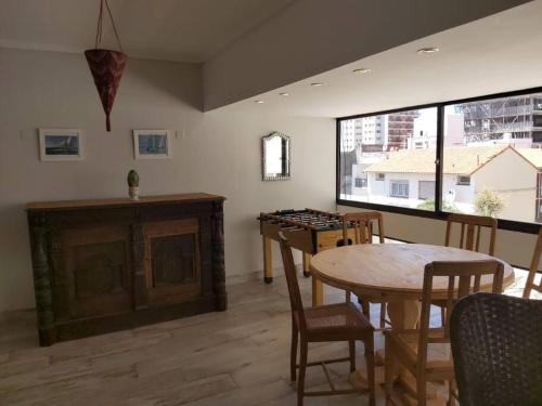 comedor con mesa, sillas y ventana en depto alem dahl en Mar del Plata