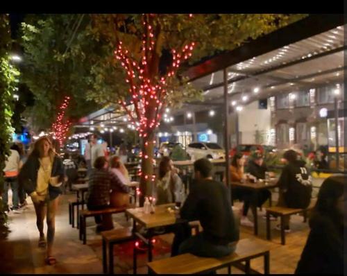 un grupo de personas sentadas en mesas en un restaurante por la noche en depto alem dahl en Mar del Plata