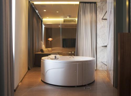 ein Bad mit einer großen weißen Badewanne in einem Zimmer in der Unterkunft Hotel Russia in Skopje