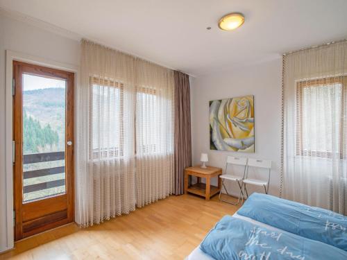a bedroom with a bed and a table and a window at Modern Holiday Home in Nordenau with Private Terrace in Schmallenberg