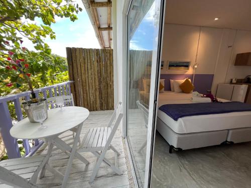 a bedroom with a bed and a table on a balcony at Saint Germain Wind Residence in Icaraí