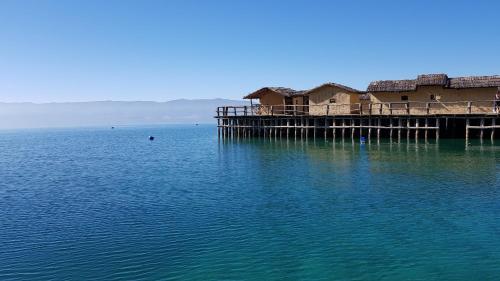 a pier in the water with a house on it at TopFloor Ohrid in Ohrid