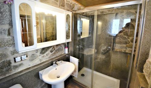 een badkamer met een wastafel, een douche en een toilet bij A Casa das Barreiras in Meis