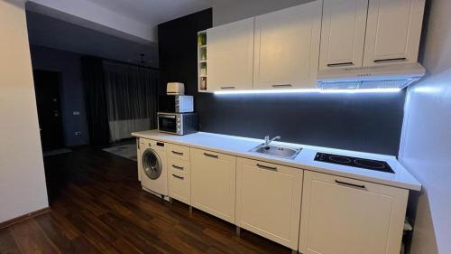 a kitchen with a sink and a washer and dryer at Apartament DoDe Predeal in Predeal