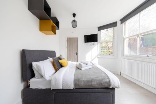 1 dormitorio con 1 cama con sábanas y almohadas blancas en Double Ensuite Sleeps 2 Long Term Welcome With Garden View en Londres