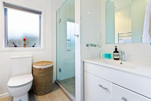 y baño con aseo y ducha acristalada. en Cascade Cottage with Parking and Wi-Fi, en Auckland