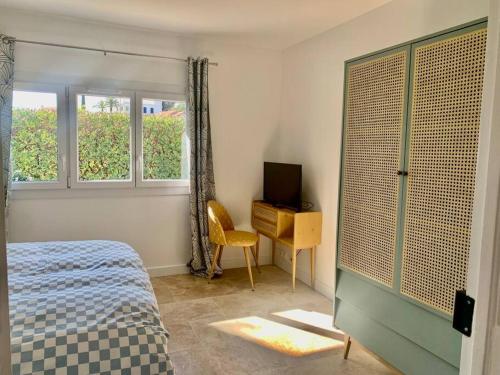 a bedroom with a bed and a desk and two windows at La Reposée, bas de villa en plein cœur de Vence in Vence