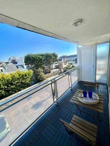 un balcon avec une table et des chaises sur un balcon dans l'établissement Plage, piscine, terrasse & centre-ville à Quiberon, à Quiberon