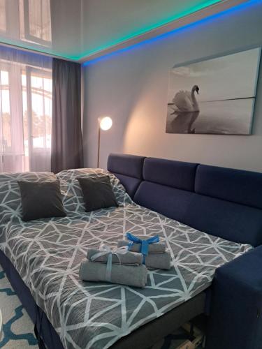 sypialnia z łóżkiem i niebieską kanapą w obiekcie Apartament Augustów SWAN w mieście Augustów