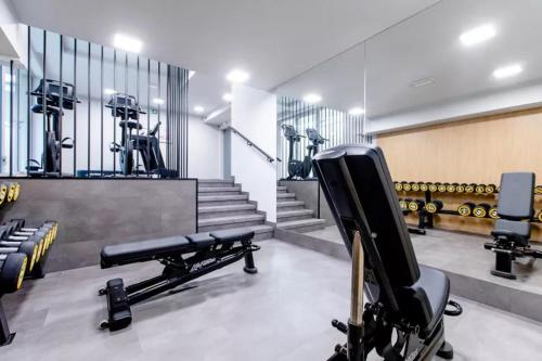 a gym with a row of exercise equipment and a bench at Apartamenty Klifowa Rewal - Strefa Rekreacji in Rewal