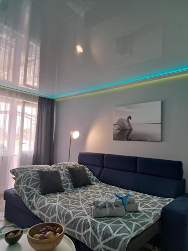 a bedroom with a bed and a blue couch at Apartament Augustów SWAN in Augustów
