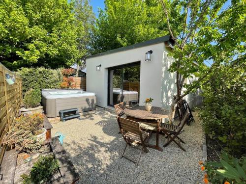 a small backyard with a table and a hot tub at Logement entier avec jacuzzi en provence in Le Thor