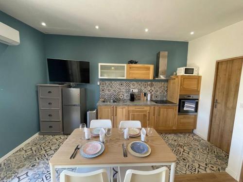 a kitchen with a wooden table with chairs and a kitchen with at Logement entier avec jacuzzi en provence in Le Thor