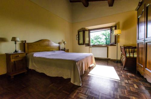 een slaapkamer met een groot bed en een raam bij Agriturismo La Castellina in Fucecchio