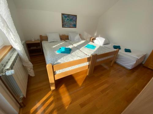um quarto com uma cama e piso em madeira em PLITVICE OAZA MIRA em Smoljanac