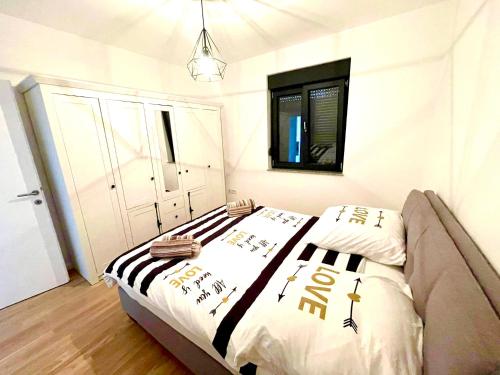 - une chambre dotée d'un lit avec des draps noirs et blancs dans l'établissement Apartment Aron, à Biograd na Moru