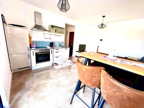 La cuisine est équipée d'une table, de chaises et d'un réfrigérateur. dans l'établissement Apartment Aron, à Biograd na Moru