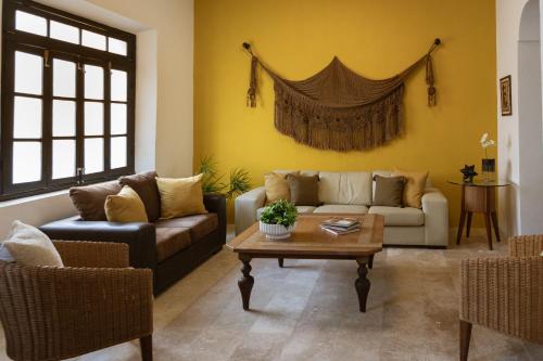 a living room with two couches and a coffee table at Casa Ubicada en el corazon de Merida, AC y piscina! in Mérida