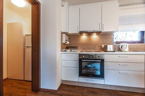 a kitchen with white cabinets and a stove top oven at APARTMENT jČop LJUBLJANA in Ljubljana