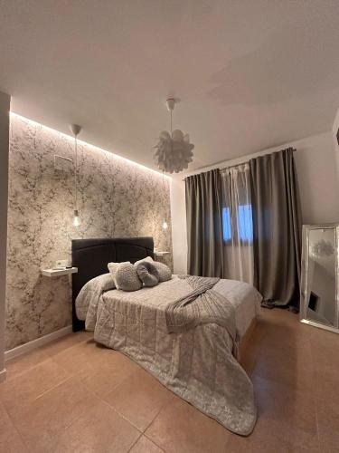 a bedroom with a bed and a stone wall at Apartamentos Esencia in Ronda