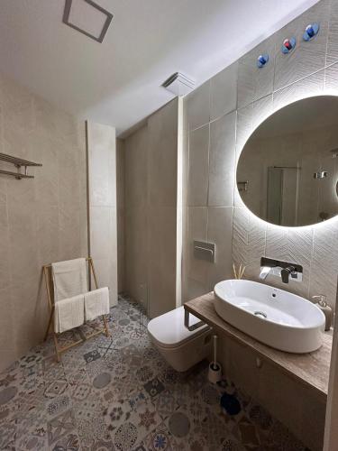 a bathroom with a sink and a toilet and a mirror at Apartamentos Esencia in Ronda