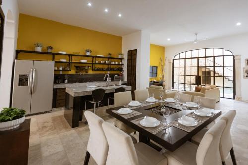 a kitchen and dining room with a table and chairs at Casa Ubicada en el corazon de Merida, AC y piscina! in Mérida