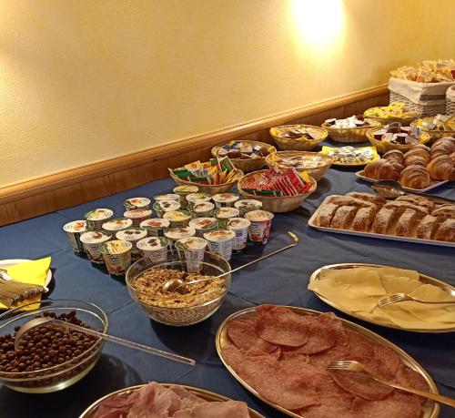 パッソ・デル・トナーレにあるHotel Cielo Blúのさまざまな種類の食べ物が並んだテーブル