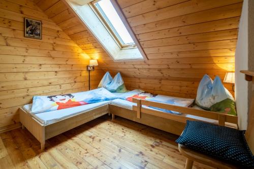 a room with two beds in a wooden cabin at Zirbenhütte am Falkert auf der Heidi-Alm in Koflach