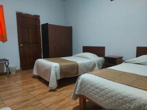 a bedroom with two beds and a wooden floor at HOSTAL espinoza in Arequipa