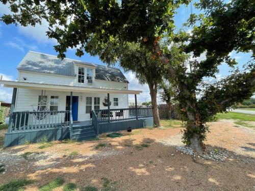 a white house with a tree in front of it at The Paddock House at Blanco Texas in Blanco