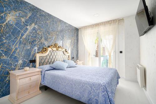 1 dormitorio con cama y pared azul en Alojamiento Barco de Valdeorras en Vegamolinos