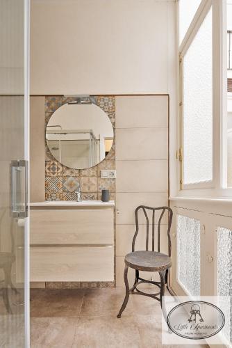 a chair in a room with a mirror at La Linda Little Apartments in Cádiz