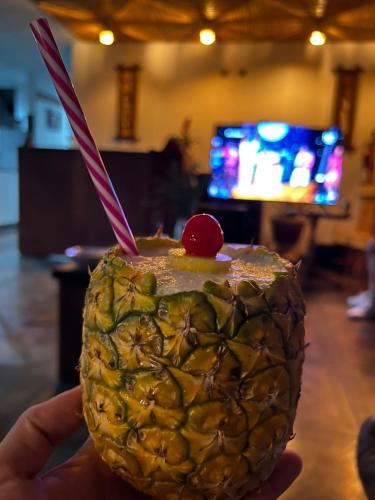 a person holding a pineapple with two straws in it at Casa De Las Flores Hotel SPA in Villa de Leyva