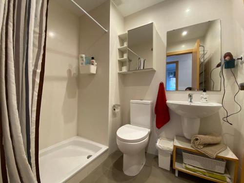 een witte badkamer met een toilet en een wastafel bij Oasis familiar Terrassa in Terrassa